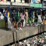 Mahasiswa KKN Universitas Khairun Ternate bersama warga membersihkan sampah di Kampung Makassar Timur, Kota Ternate.