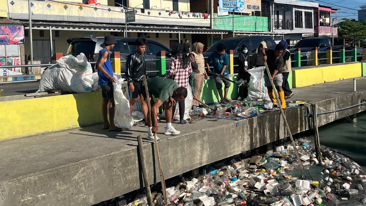 Mahasiswa KKN Universitas Khairun Ternate bersama warga membersihkan sampah di Kampung Makassar Timur, Kota Ternate.