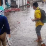 Asesor pendidikan terpaksa menggulung celana untuk melintasi banjir rob saat bertugas di Desa Jorjoga, Taliabu Utara.